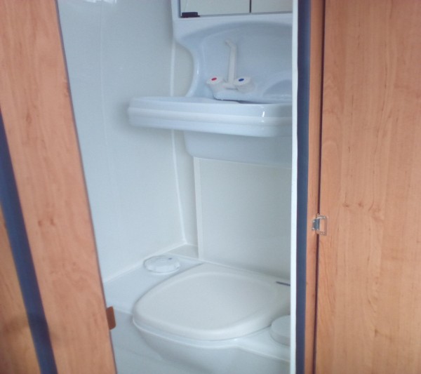Toilet with flip down sink in campervan conversion by Céide Campervan Conversions