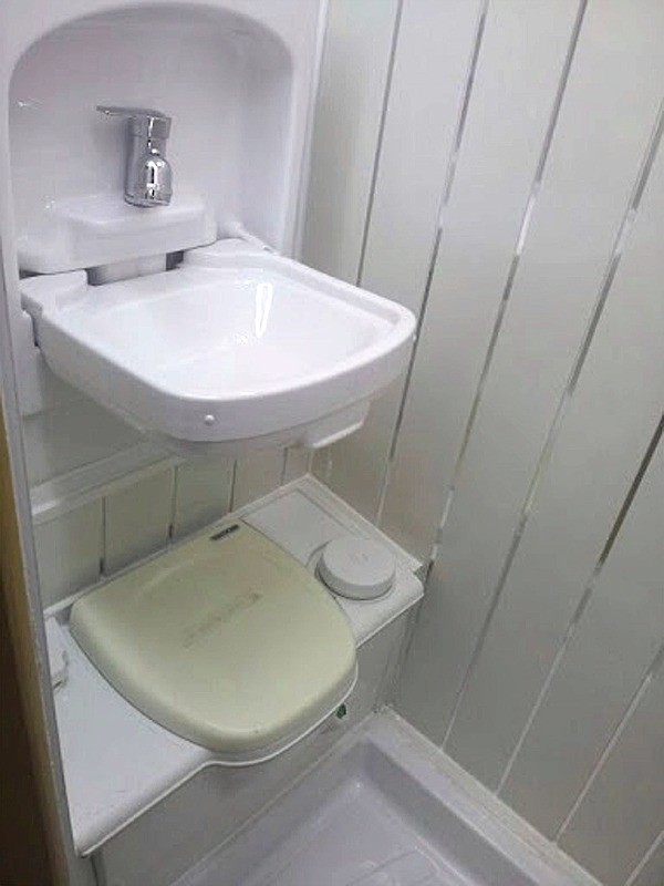 Toilet with fold up sink above for efficient use of space in in van interior converted by Céide Campervan Conversions, Co. Donegal,  Ireland
